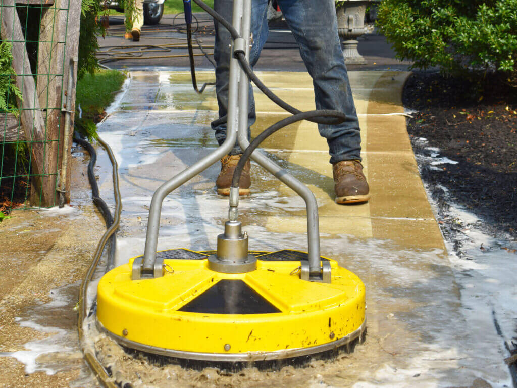Sidewalk pressure washing with a high-powered surface cleaner for a deep and even clean.