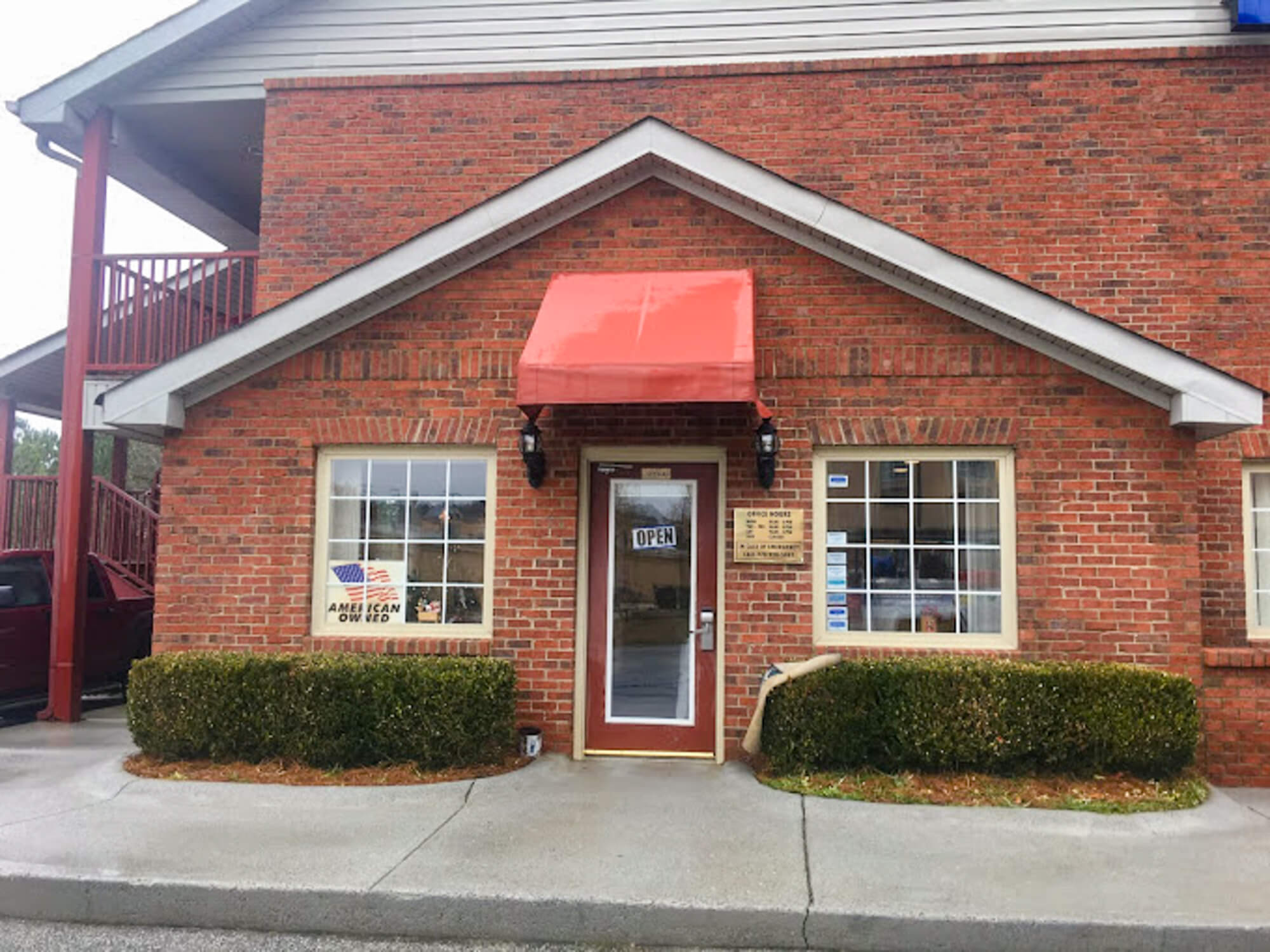Commercial storefront with a clean concrete sidewalk and fresh canvas awning after professional pressure washing service.