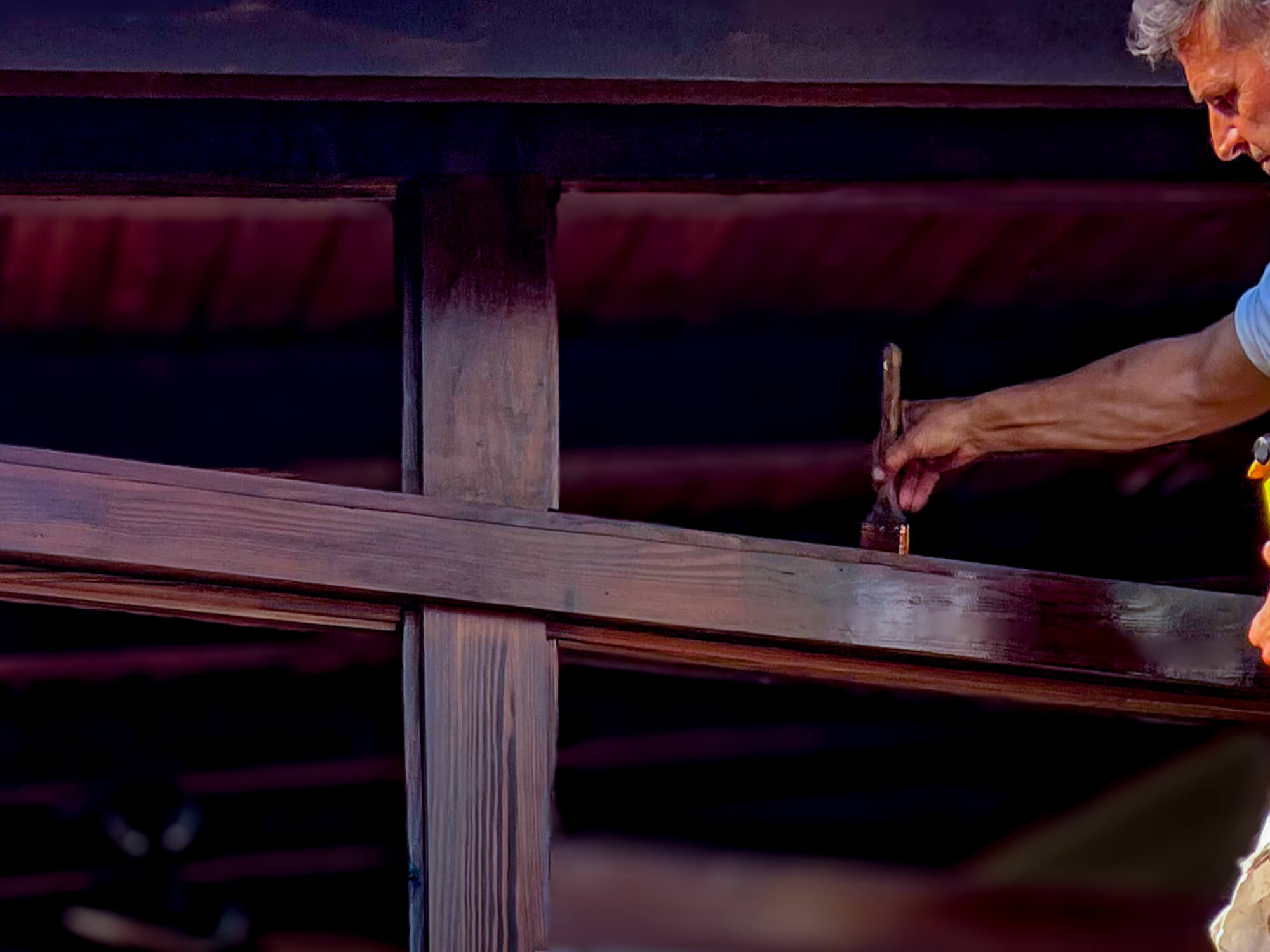 Expert Deck Staining & Restoration Services - MAN'S HAND BRUSHING STAINING THE TOP OF AN EXTERIOR DOOR FRAME