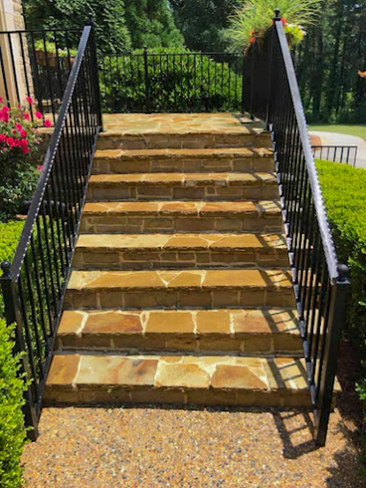 Stone paver steps, front stoop, wrought iron railing, and concrete sidewalk looking spotless after professional pressure washing.
