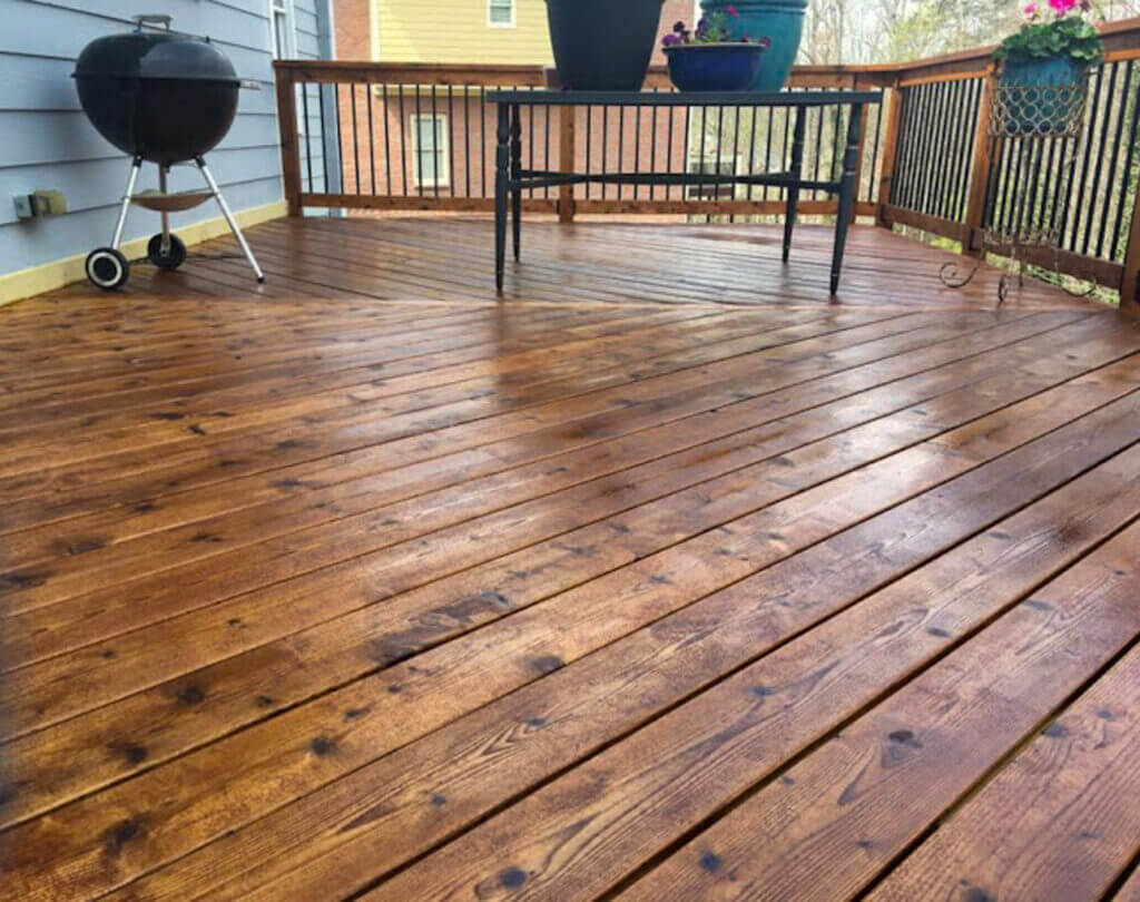 Closeup of rich HARDwood DECK  WITH a freshly hand-stained AND OILED back deck, showcasing expert craftsmanship by Blue Monkey Wood Care.