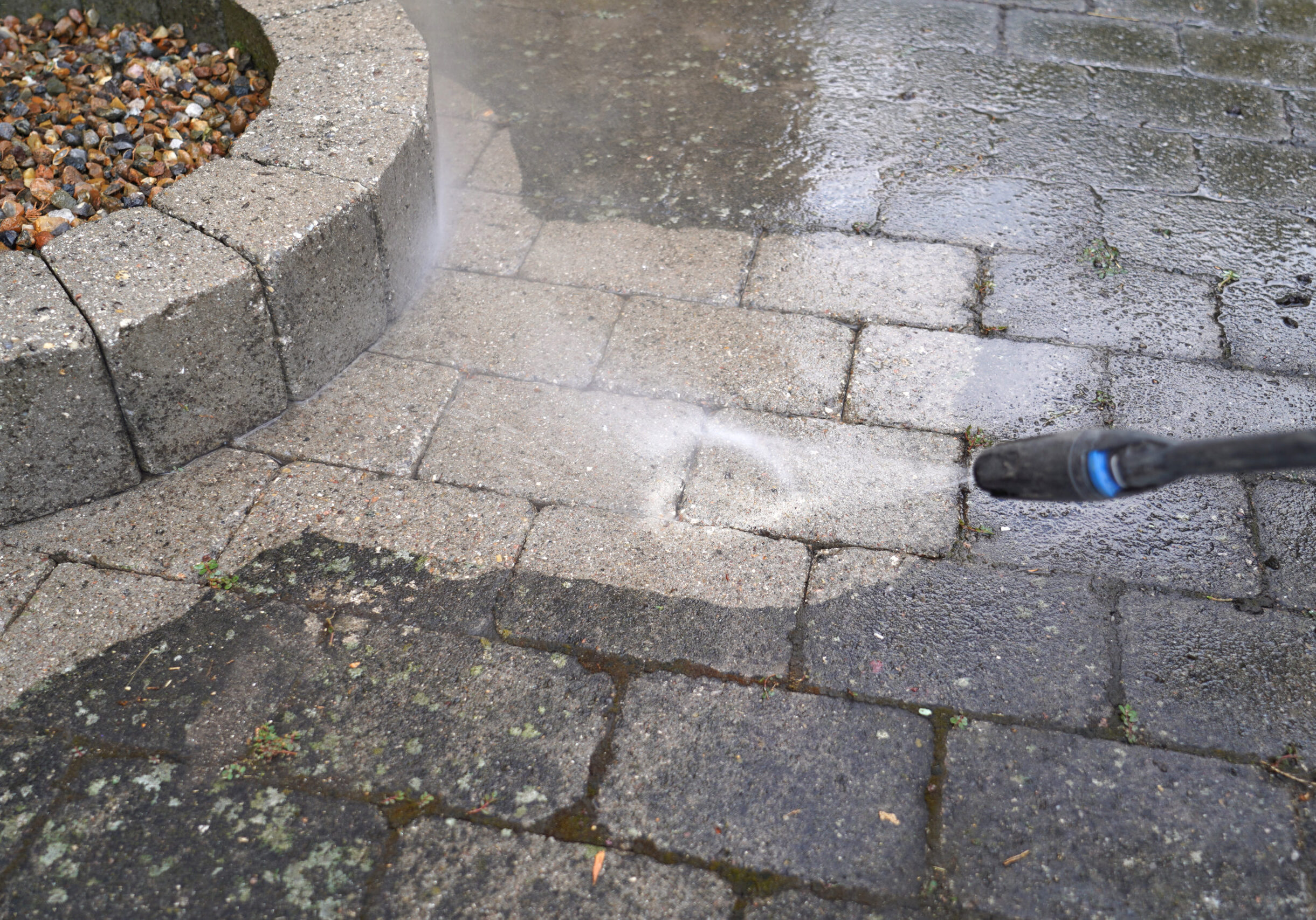 Stone Pavers Sidewalk pressure washing with a high-powered surface cleaner for a deep and even clean. Title: Advanced Driveway & Sidewalk Pressure Washing