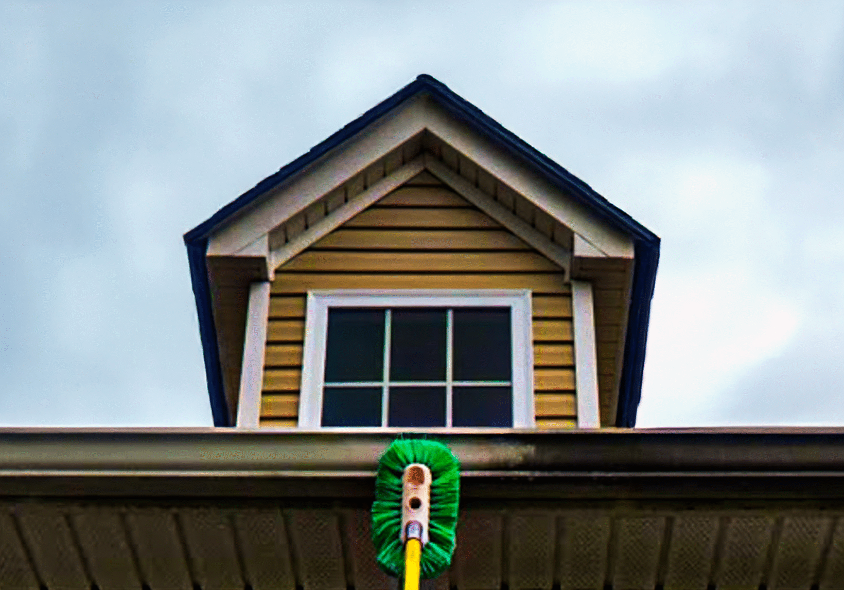Professional cleaner removing stains from a gutter using safe cleaning solutions.