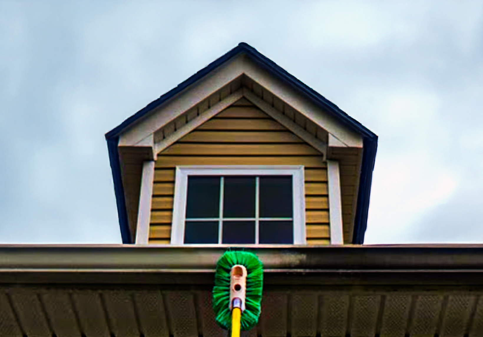Professional cleaner removing stains from a gutter using safe cleaning solutions.