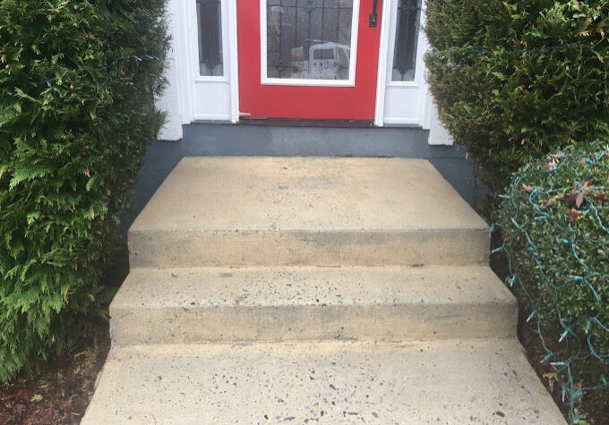 Freshly pressure-washed concrete stoop, stairs, and walkway with a bright, clean finish, removing dirt, stains, and grime. CONCRETE STAIN REMOVAL, CONCRETE SEALING, CONCRETE PRESSURE WASHING
